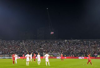 A flag with Albanian national symbols attached to a remotely operated drone flies in the stadium during brawl between players on the pitch during the UEFA EURO 2016 group I qualifying soccer match between Serbia and Albania is abandoned in Belgrade, Serbia on October 14, 2014. Match officials abandon Tuesday's Euro 2016 qualifier between Serbia and Albania after a drone carrying an Albanian flag entered the stadium late in the first half and sparked a brawl between players and fans.