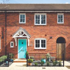 A red brick house with turquoise front door