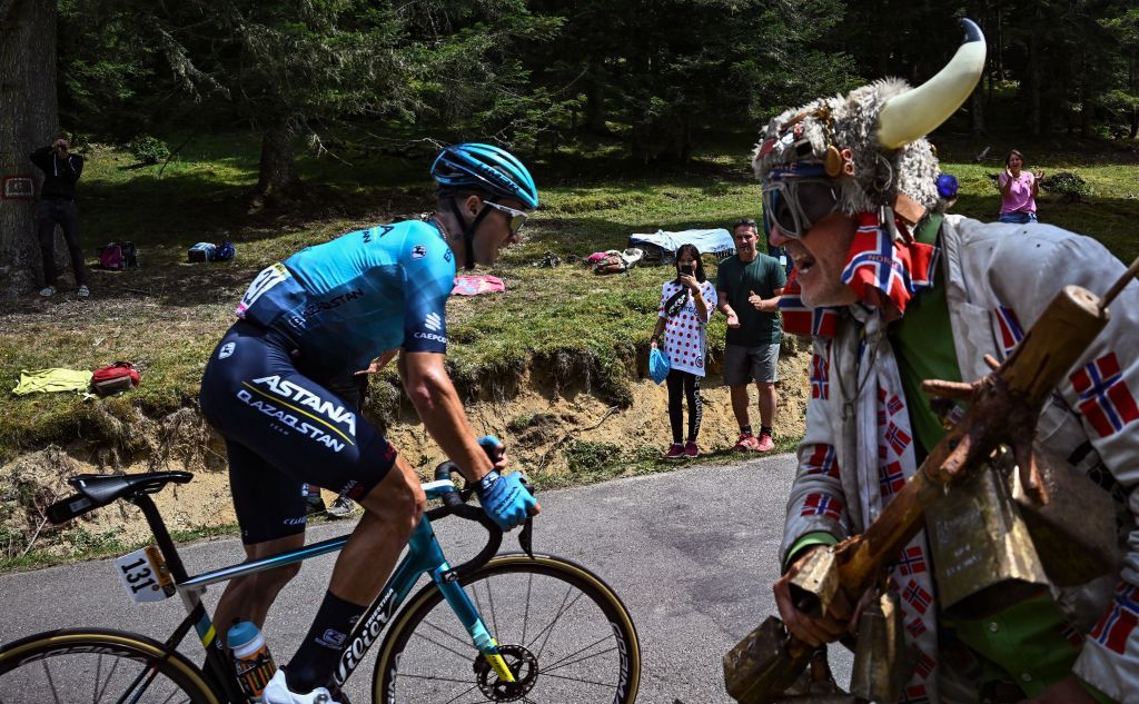 A spectator rings cow bells and cheers as AstanaQazaqstan Teams Kazakh rider Alexey Lutsenko cycles in a breakaway during the 17th stage of the 109th edition of the Tour de France cycling race 1297 km between SaintGaudens and Peyragudes in southwestern France on July 20 2022 Photo by AnneChristine POUJOULAT AFP Photo by ANNECHRISTINE POUJOULATAFP via Getty Images