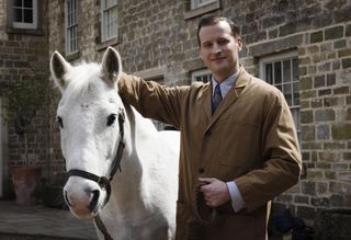 Nicholas Ralph as James Herriot with a horse in All Creatures Great and Small.