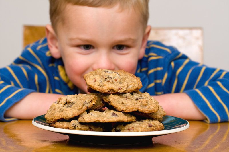 Boy staring at a delicious plate of cookies.