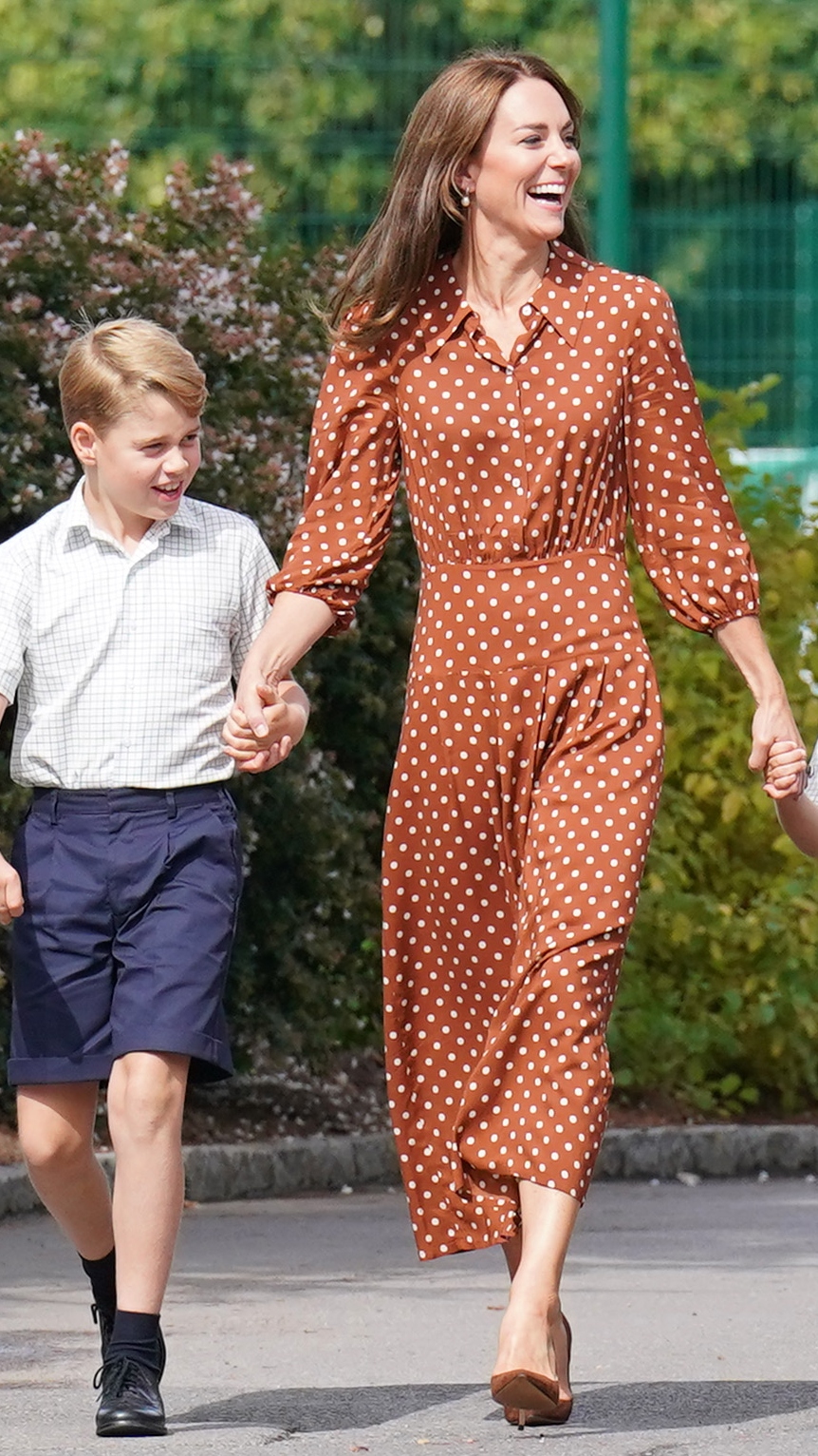Prince George holds the hand of Catherine, Princess of Wales, who's laughing, as they arrive for a settling in afternoon at Lambrook School on September 7, 2022