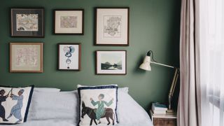 Farrow & Ball green bedroom with gallery wall and printed cushions