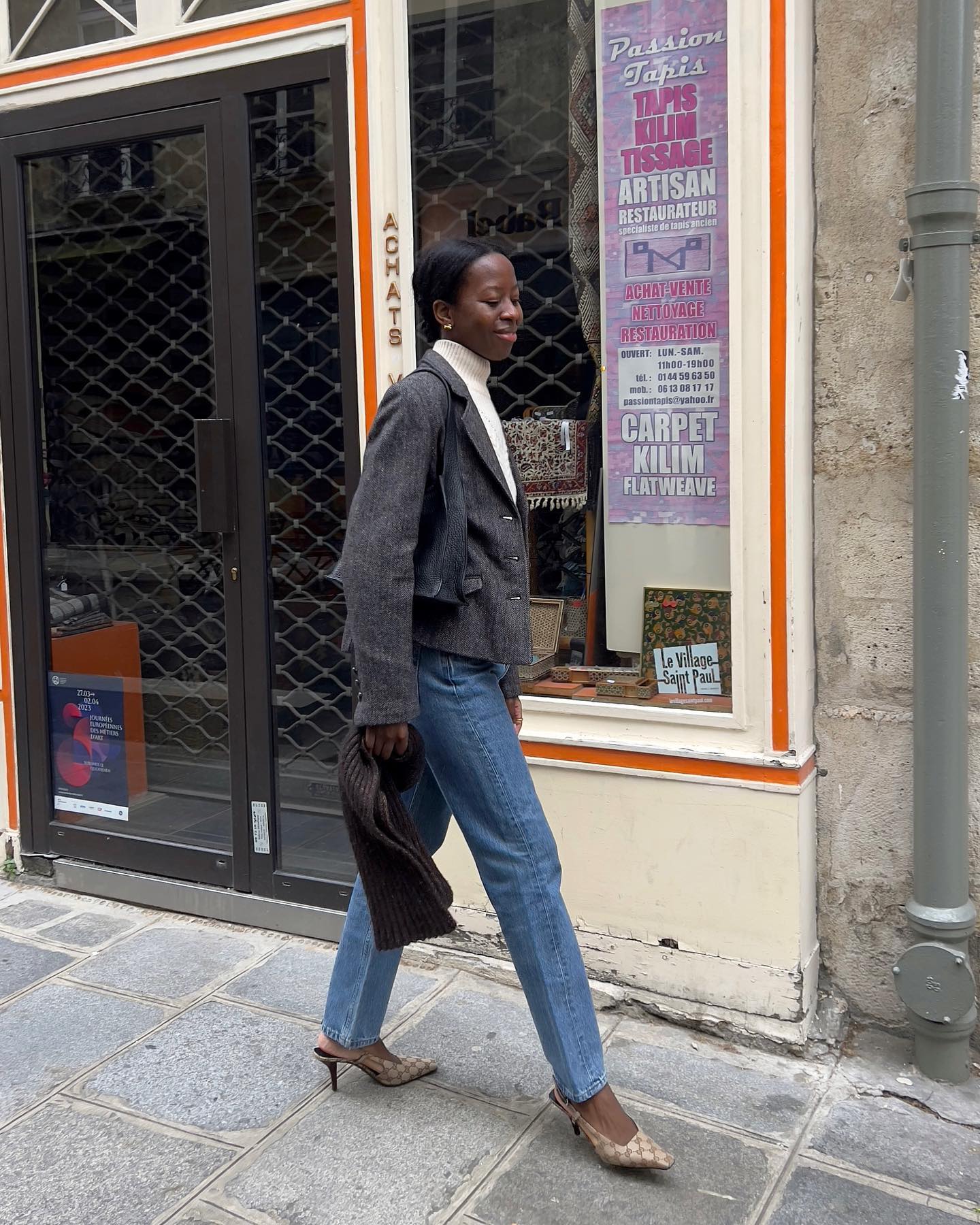 An image of @sylviemus_ wearing denim jeans with a grey blazer while in Paris.