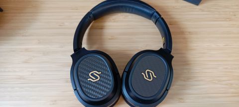 A pair of black Edifier Stax Spirit S3 headphones on a wooden desk