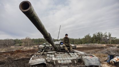 A Ukrainian serviceman sits on a T-80 tank in eastern Ukraine on 29 December 2022