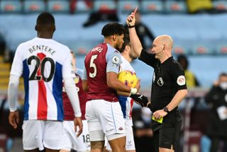 Tyrone Mings is shown a red card