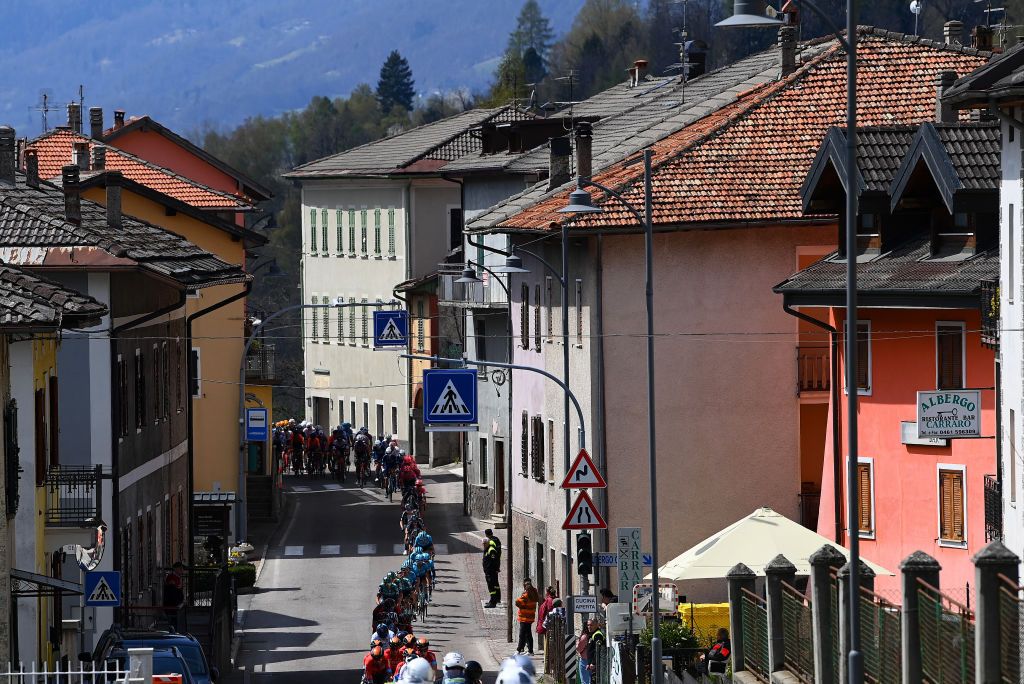 SAN MARTINO DI CASTROZZA ITALY APRIL 18 A general view of the peloton passing through a village landscape during the 45th Tour of the Alps 2022 Stage 1 a 1609km stage from Cles to PrimieroS Martino di Castrozza 708m TouroftheAlps on April 18 2022 in San Martino di Castrozza Italy Photo by Tim de WaeleGetty Images