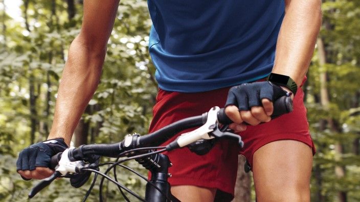 Man cycling while wearing Fitbit Charge 4