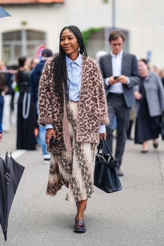 woman wearing leopard print cardigan button down shirt, snake print skirt, and loafers