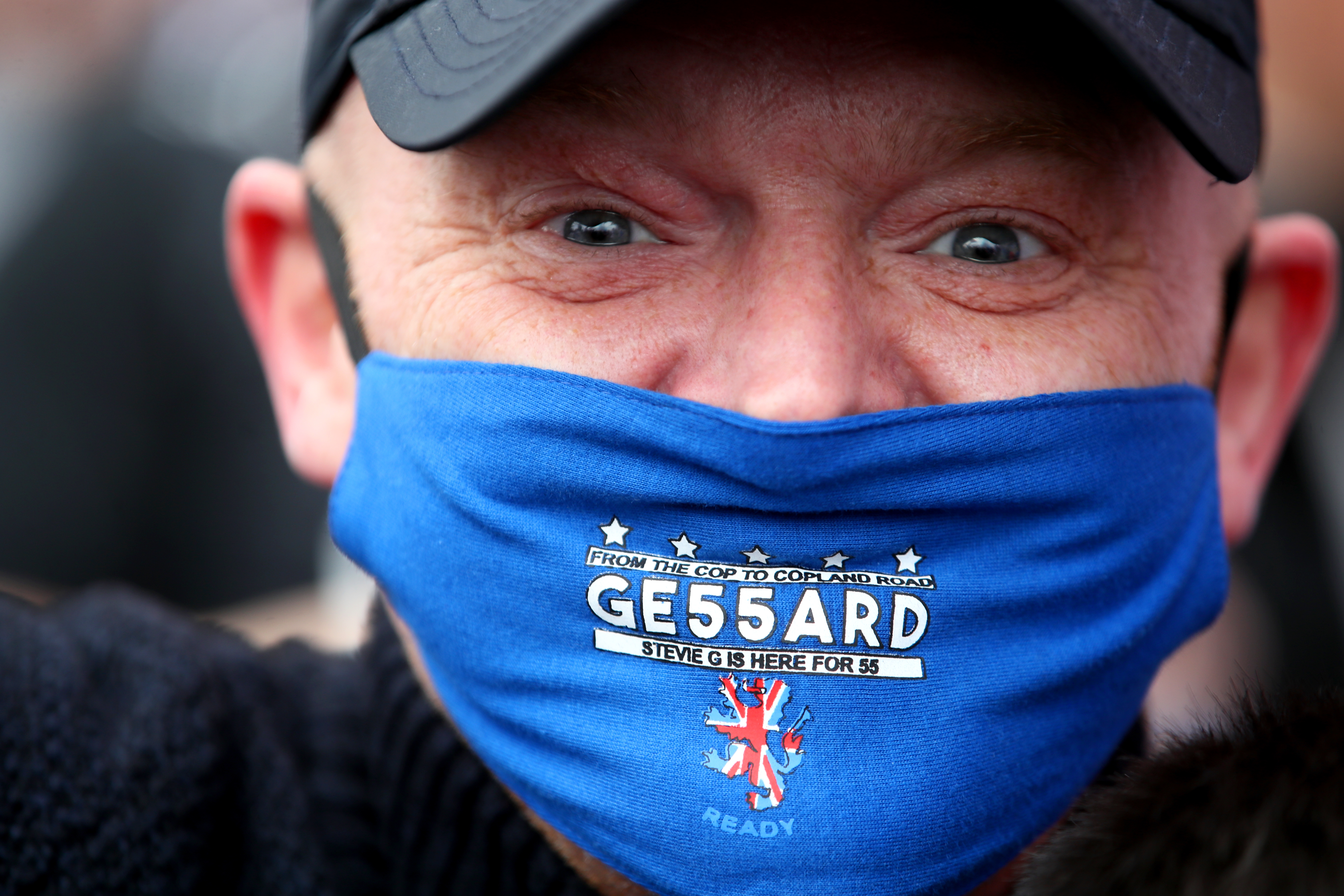 A Rangers fan wears a celebratory face mask