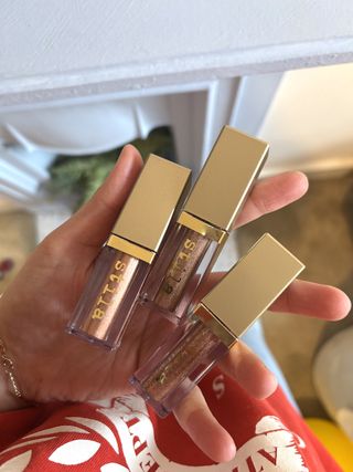 Mica Ricketts holding three tubes of Stila Glitter & Glow Liquid Eye Shadow