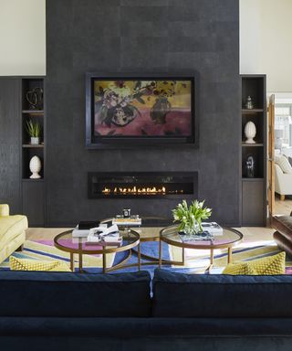 Dark living room wall with navy blue and yellow sofas