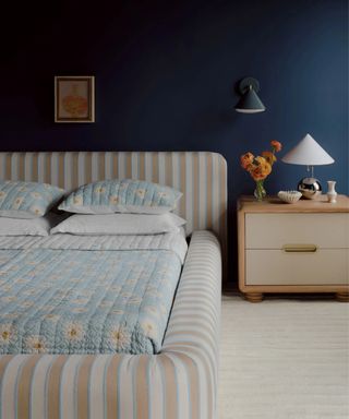 bedroom from the anthropologie artful aesthete bedroom with a beige and blue striped upholstered bed and chrome decor