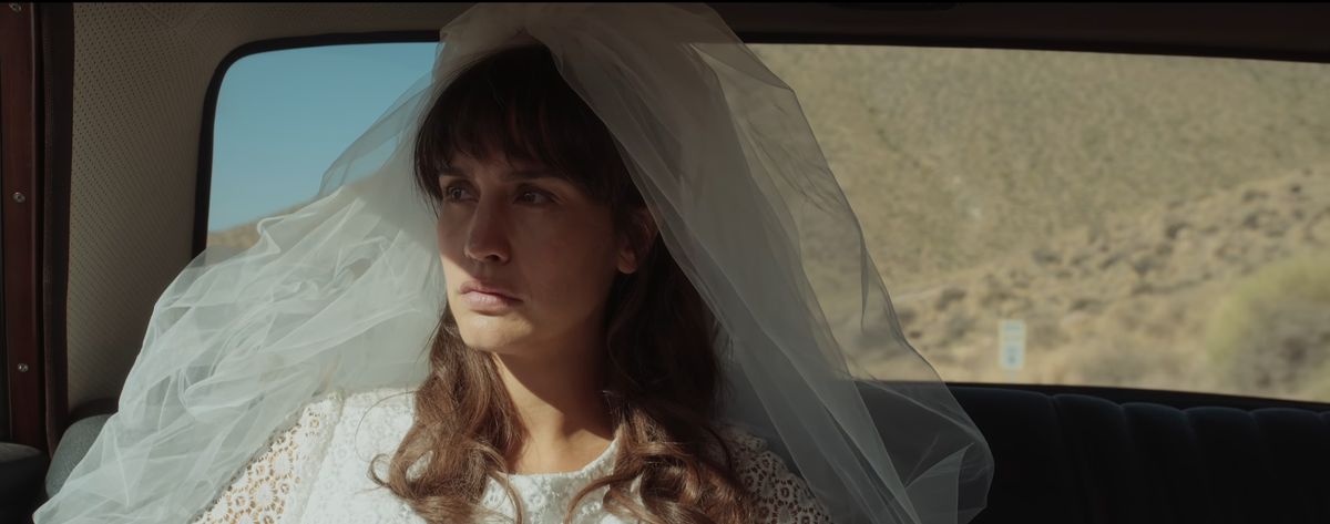 Maria wearing a veil looking out of the car window in Between Lands episode 1.