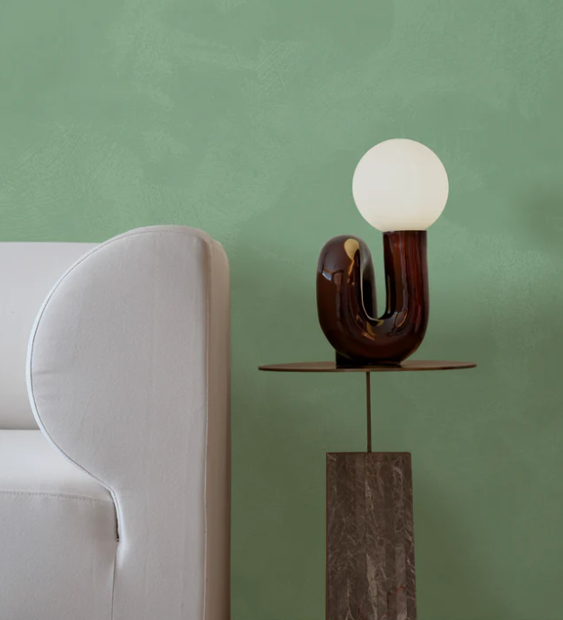 Impera Italia limewash paint in a living room featuring a sofa, side table, and orb table lamp