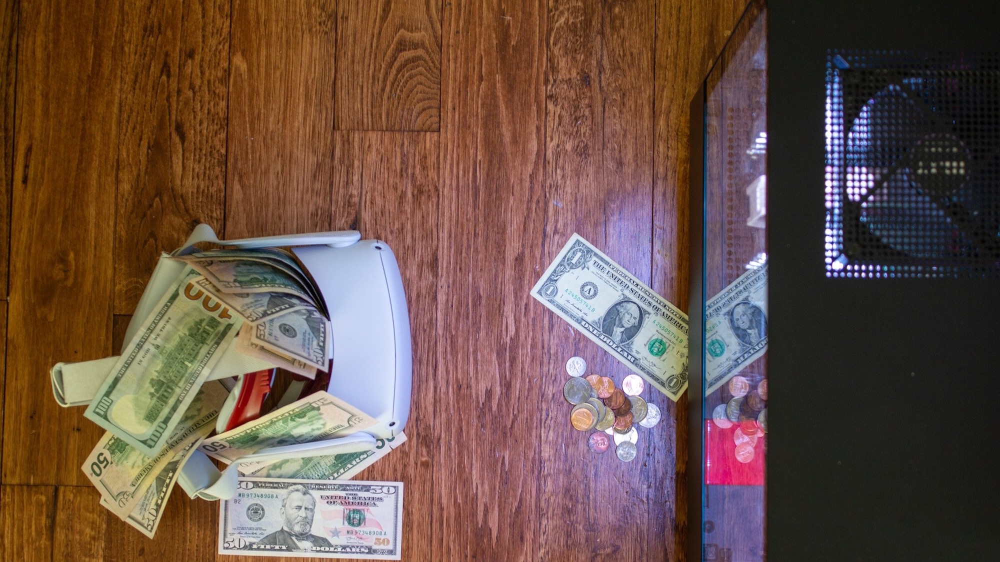 A Quest 2 covered in piles of cash sitting next to a PC