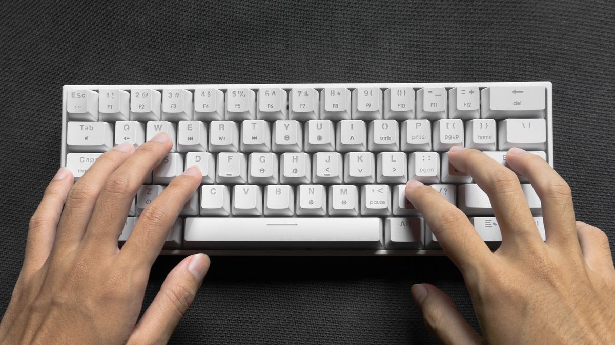 An image of someone typing on a white wireless mechanical keyboard