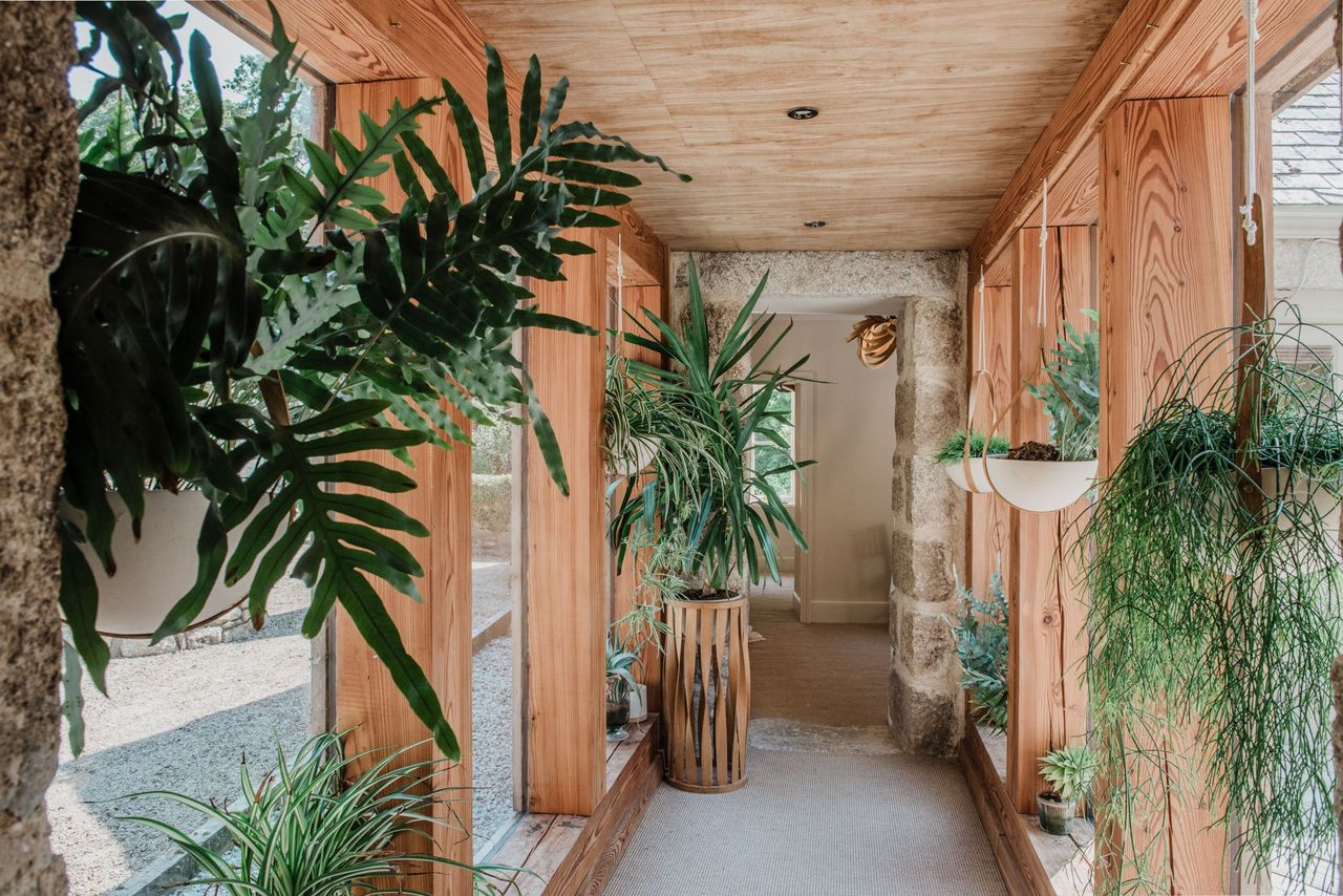 The walkway between the homes shows timber beams leading into a stone archway
