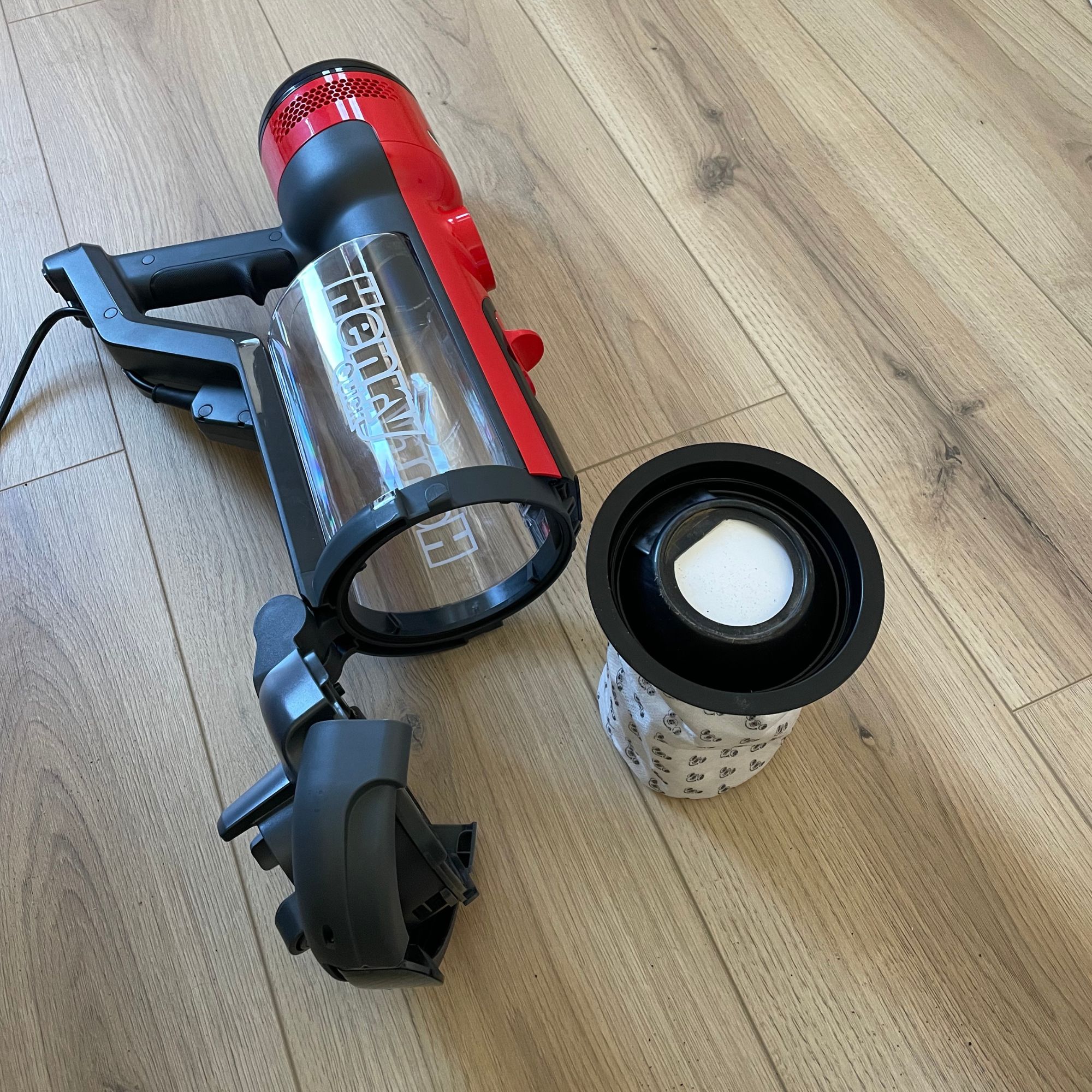 Henry Quick Corded Vacuum Cleaner handheld section with the dust canister open and a dust bag sitting next to it