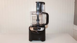 Oster Total Prep 10 Cup Food Processor processing on kitchen counter