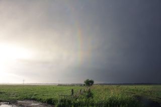 quaternary rainbow in sky above field