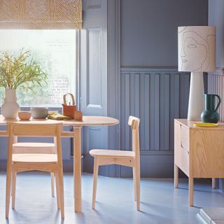 Pale blue dining room with blue walls and matching floor, with a wooden dining room table and chairs