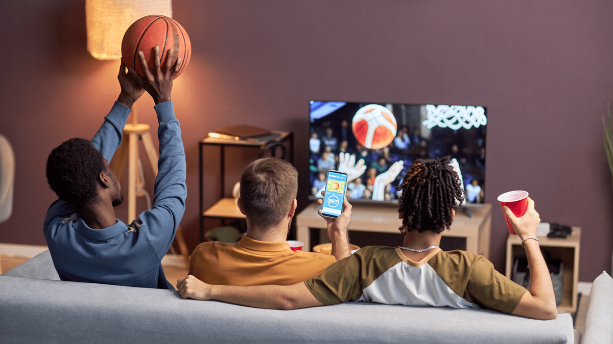 three young men watching basketball 