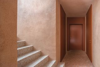 A terrazzo staircase leads to a terracotta walled basement