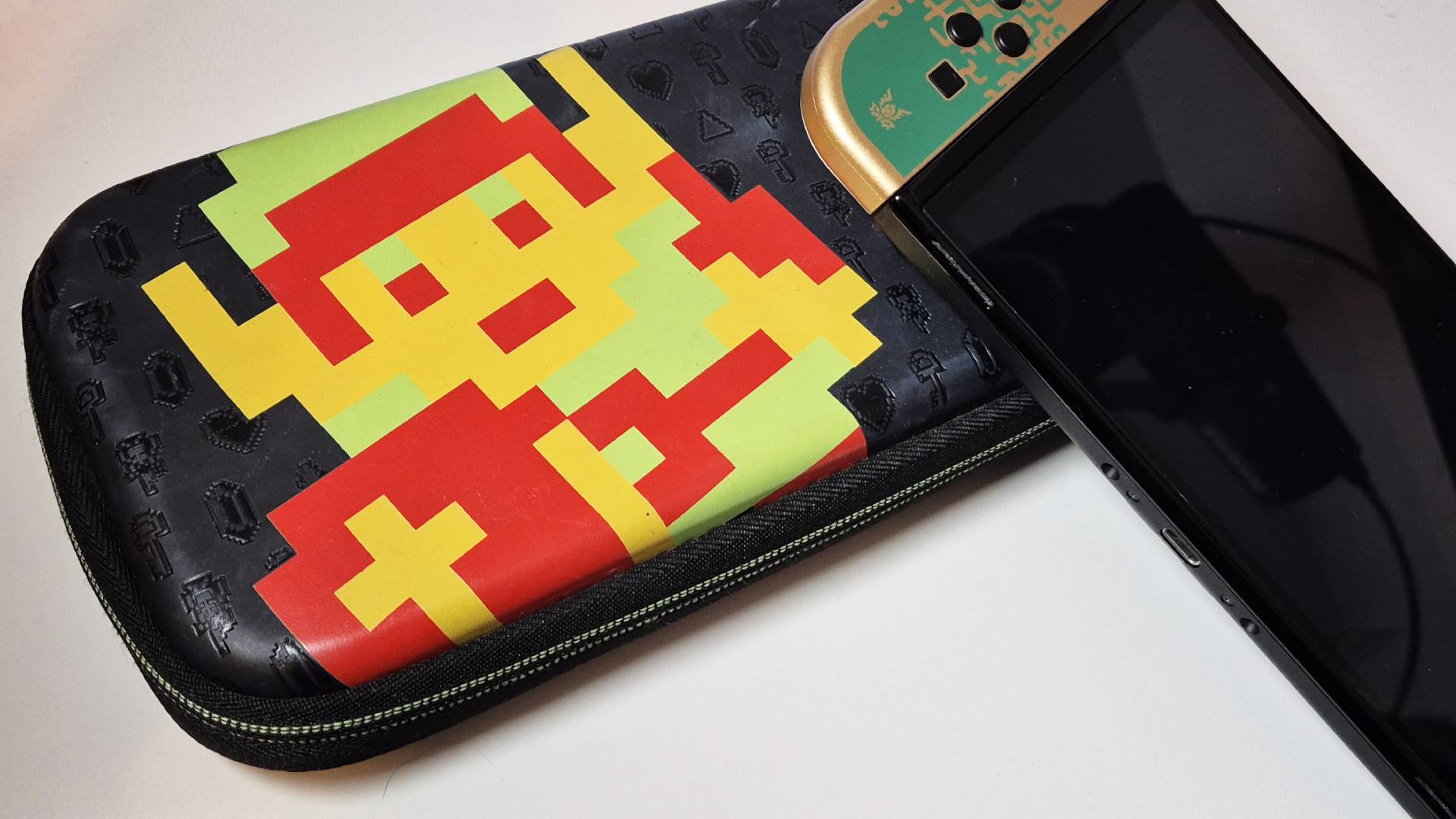 Image of the official PDP 'Retro Link' original Switch case, with the Tears of the Kingdom OLED Switch sitting on top of it, taken by writer Rosalie Newcombe.