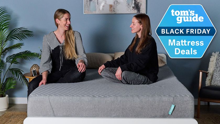 Two women sitting on the Siena Signature Memory Foam mattress with a Tom&#039;s Guide Black Friday Mattress Deals badge overlaid