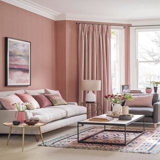 pink walls and a cream sofa with pink curtains