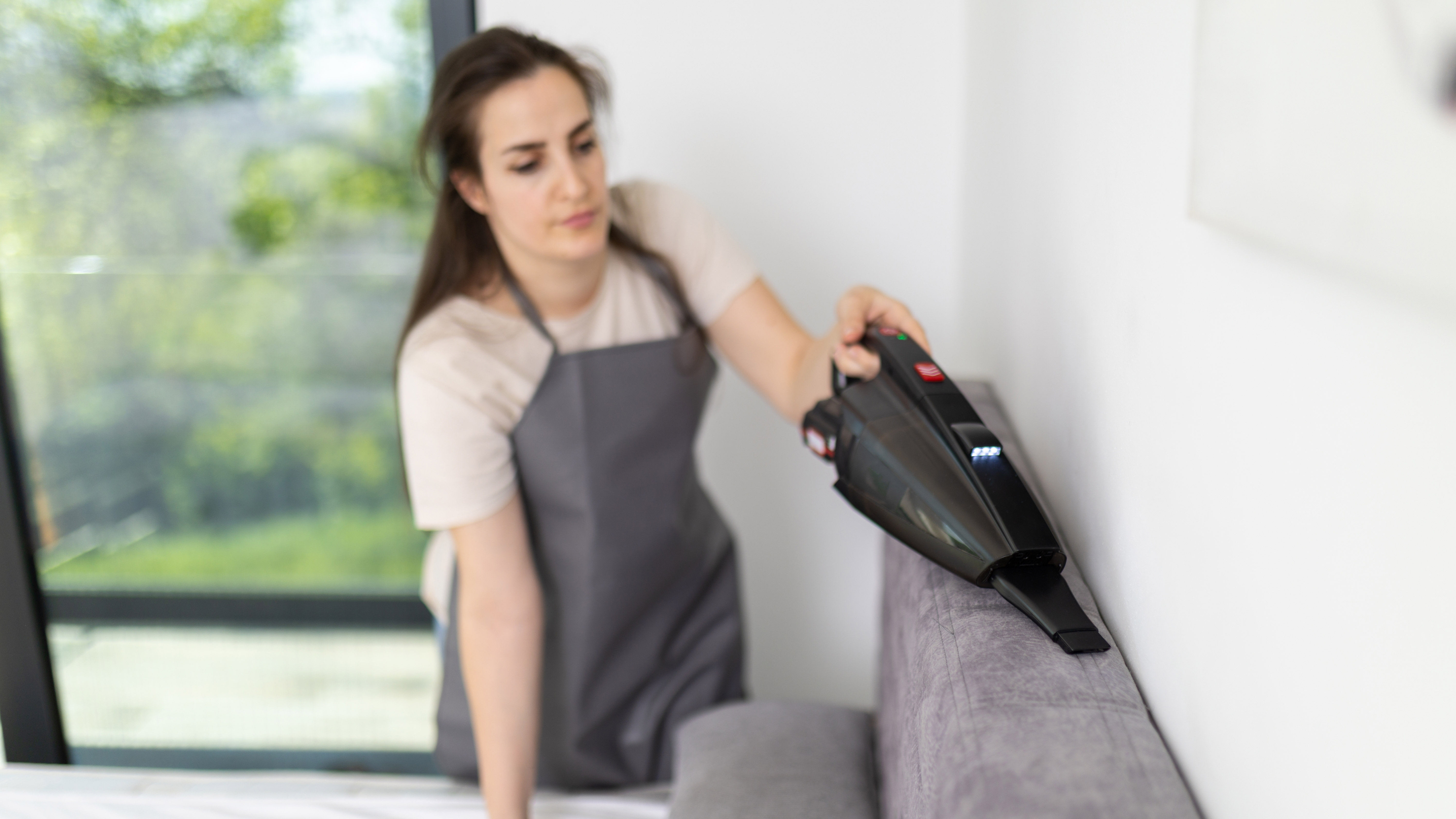 Woman vacuuming bedframe