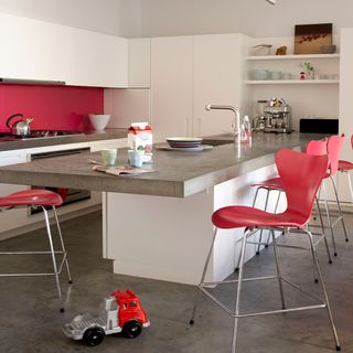 dining room with concrete flooring and red chairs