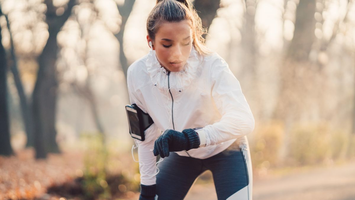 Woman checking GPS watch during winter run