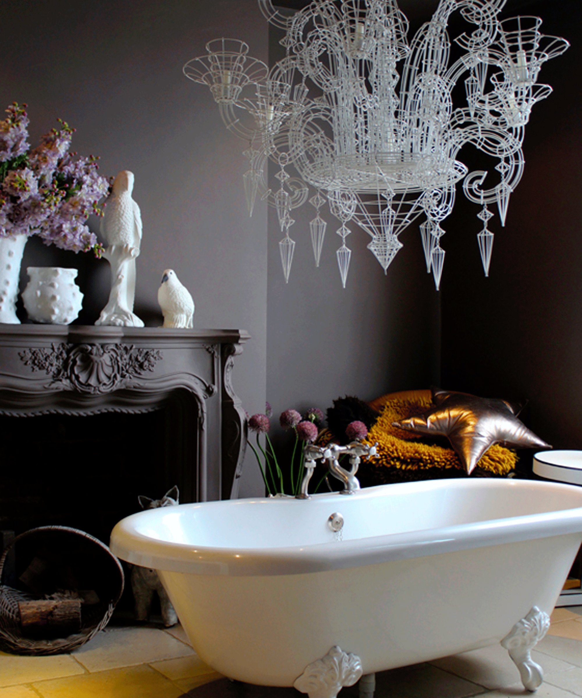 Bathroom with dark walls with freestanding bath and a chandelier