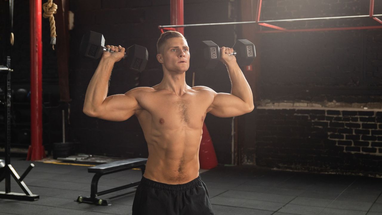 Man performing standing shoulder press