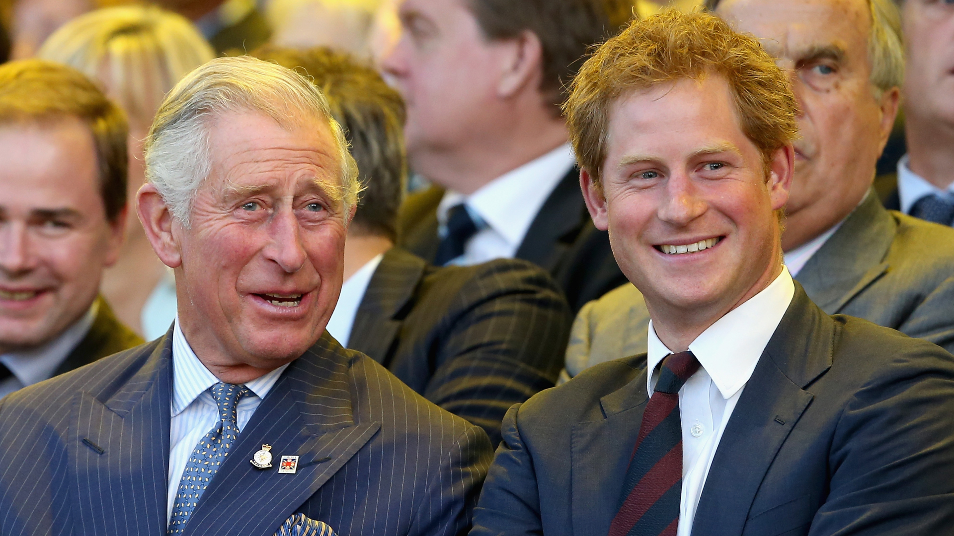 King Charles and Prince Harry laugh while wearing suits at the Invictus Games in 2014