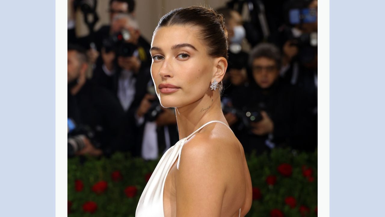 Hailey Bieber wears a white silk dress as she attends the 2022 Met Gala, for a piece on &#039;Hailey Bieber White Dress&#039;/ in a blue template