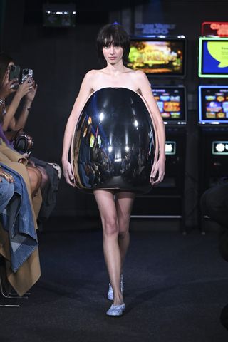 Model on runway wears JW Anderson reflective object, at London Fashion Week S/S 2023