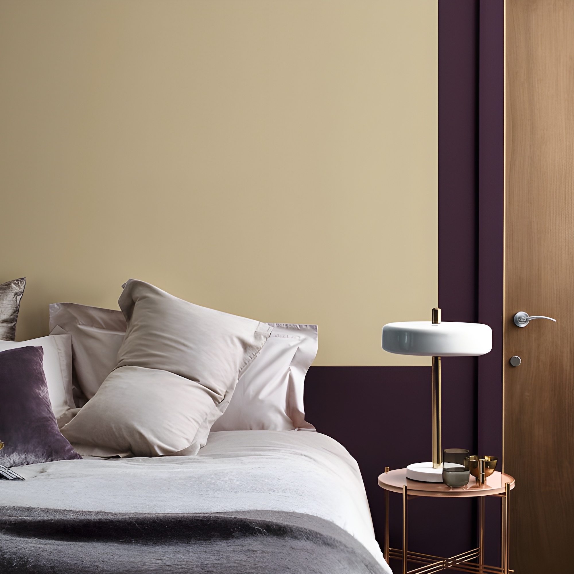 bedroom with butter yellow and burgundy painted walls and bedside table with lamp on