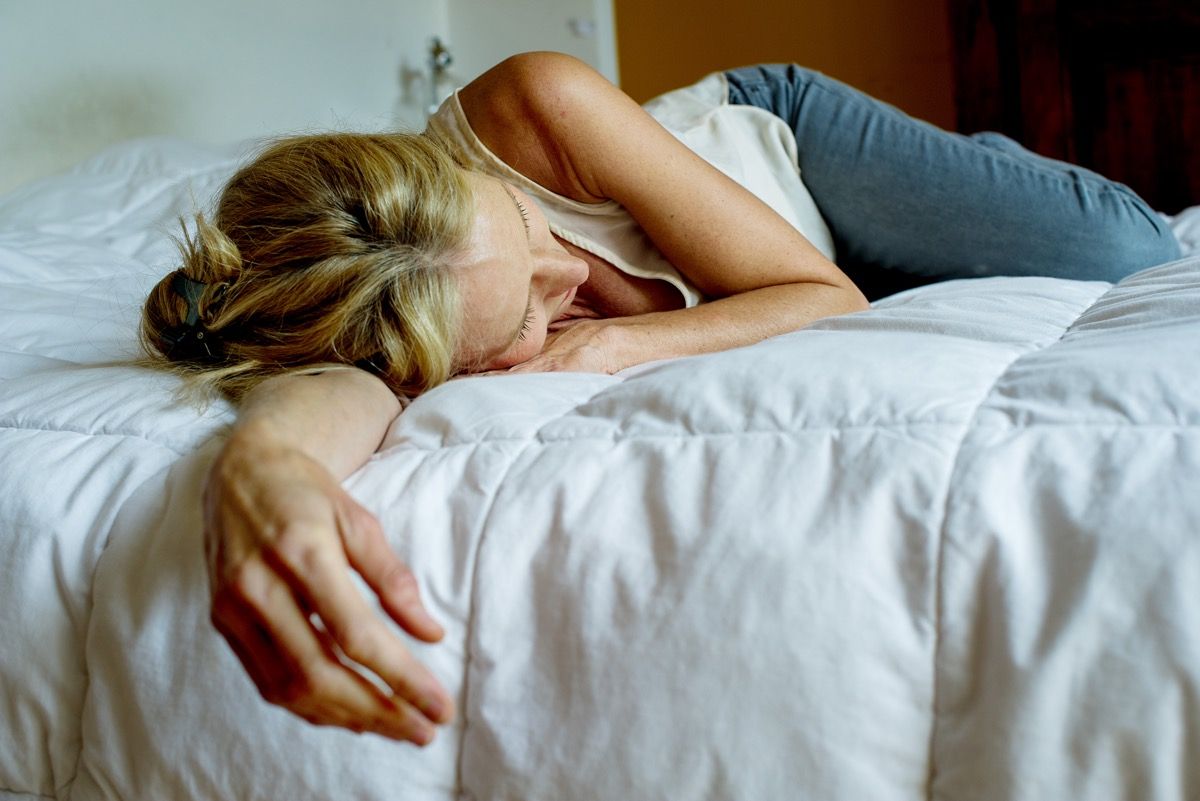 Depressed woman lying in bed.