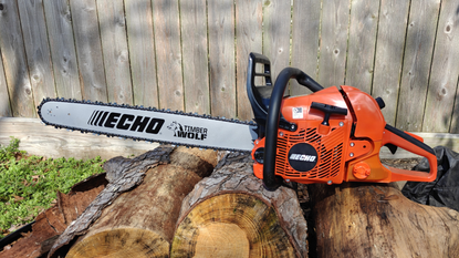 The Echo CS-590 chainsaw sitting on a pile of logs