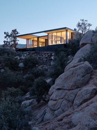 Dusk view of High Desert Retreat by Aidlin Darling Design perched on cliffside