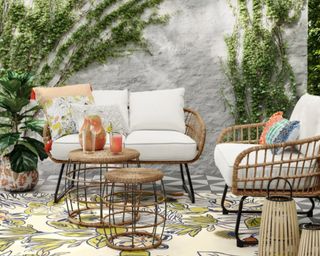 Opalhouse™ Southport 3pc Motion Chat Set in garden with white wall and lots of greenery, decorated with cushions, outdoor rug and lanters, and jug with glasses on table