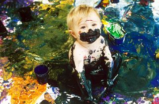 Little boy covered in paint