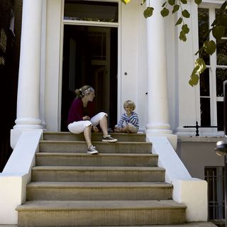 women child on stairs with exterior of house
