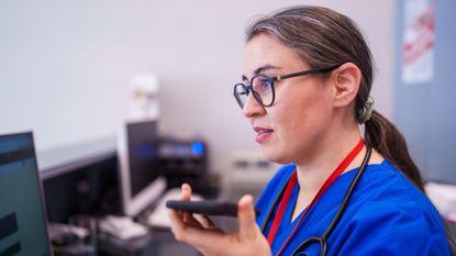 A doctor using a phone, to represent AI in healthcare.