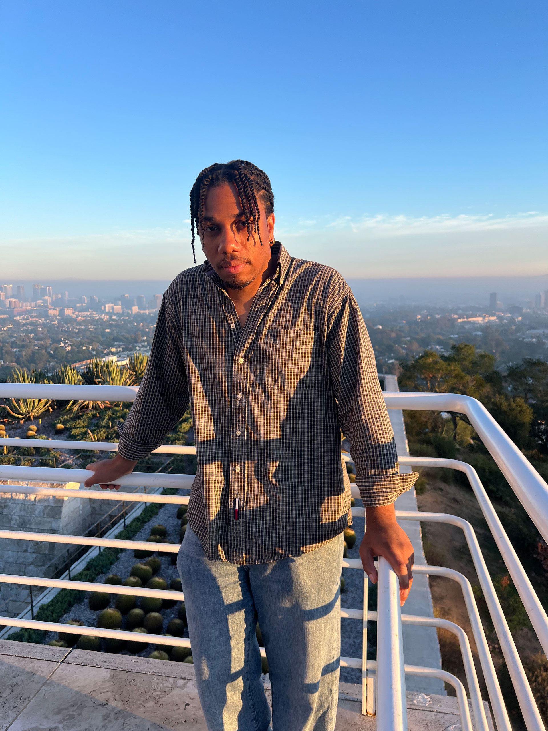 man on a balcony with view behind him