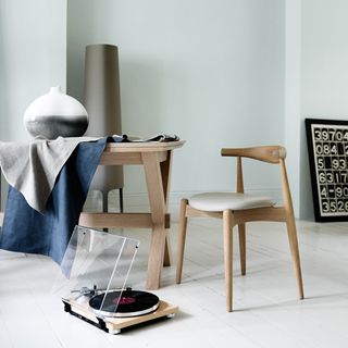 room with white wall wooden chair and wooden table